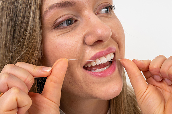 Reinigung mit Zahnseide bei einer Professionellen Zahnreinigung in Stuttgart